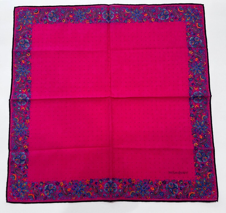Puede incluir: Un pa&ntilde;uelo de seda rosa con un borde paisley en tonos de azul, naranja y amarillo.