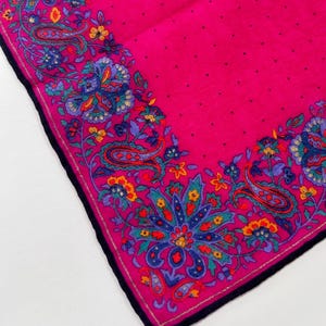 Puede incluir: Un pa&ntilde;uelo rosa con estampado paisley y borde negro. El pa&ntilde;uelo tiene un fondo blanco con un estampado paisley rosa.