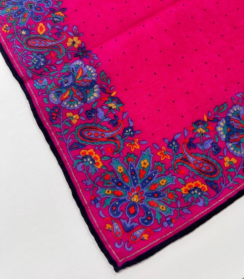 Puede incluir: Un pa&ntilde;uelo rosa con estampado paisley y borde negro. El pa&ntilde;uelo tiene un fondo blanco con un estampado paisley rosa.