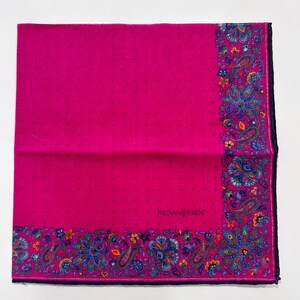 Puede incluir: Un pa&ntilde;uelo de seda rosa con un borde de paisley y el texto "Yves Saint Laurent" en negro.