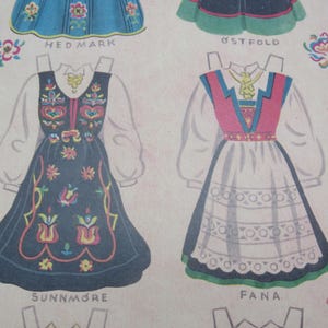 Puede incluir: Mu&ntilde;ecas de papel vintage con vestidos folcl&oacute;ricos noruegos tradicionales. Los vestidos est&aacute;n intrincadamente dise&ntilde;ados con patrones florales y bordados, en colores como el azul, el rojo y el blanco. Los nombres "HEDMARK", "SUNNM&Oslash;RE" y "FANA" est&aacute;n impresos debajo.