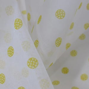 May include: White fabric with a yellow polka dot pattern. The dots are small and have a textured appearance.