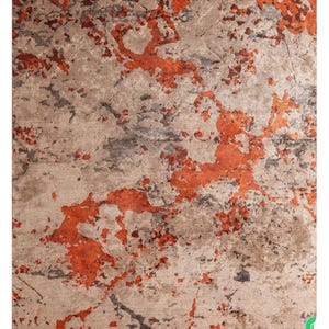 Può includere: Un tappeto rettangolare con un design invecchiato. Il tappeto presenta uno sfondo beige neutro con spruzzi di arancione bruciato e grigio. Il motivo conferisce al tappeto un aspetto strutturato.