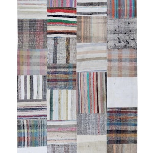 Può includere: Un tappeto patchwork con una varietà di strisce e motivi colorati. Il tappeto è realizzato con materiali riciclati e ha un aspetto rustico e vintage.