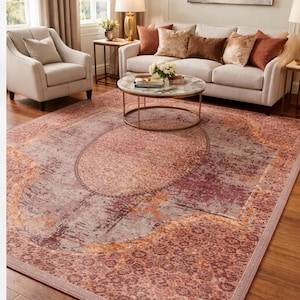 Può includere: Un grande tappeto rettangolare con un design vintage e invecchiato. Il tappeto presenta una palette di colori di rossi, viola e arancioni tenui, con un motivo a medaglione centrale e un bordo a fantasia. Il tappeto è in un salotto.