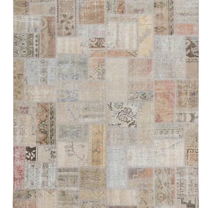 Puede incluir: Una alfombra vintage de patchwork con fondo beige y una variedad de patrones en tonos marrones, rosas y azules.