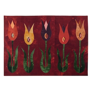 Könnte beinhalten: Ein roter Wandbehang aus Stoff mit fünf stilisierten Tulpen in Gelb-, Orange-, Rot- und Lilatönen. Die Tulpen sind in einer Reihe über die Mitte des Stoffes angeordnet.