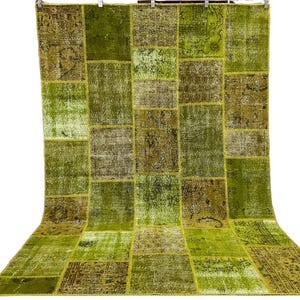 Puede incluir: Una alfombra de patchwork verde y marrón con una variedad de patrones. La alfombra está hecha de materiales reciclados y es perfecta para agregar un toque de estilo bohemio a cualquier habitación.