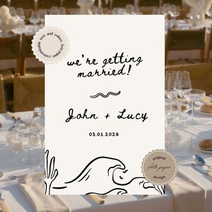 Może przedstawiać: Biała kartka z czarnym tekstem ogłaszająca ślub. Tekst brzmi "we're getting married!" po którym następuje "John + Lucy" i data "03.01.2026". Kartka ma prosty wzór fali i małe kółko z tekstem "original tote paper design".