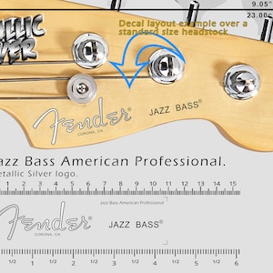 Può includere: Primo piano di una paletta Fender Jazz Bass con la scritta "METALLIC SILVER". L'immagine mostra il logo Fender e la scritta "JAZZ BASS". La paletta è larga 23,00 cm.