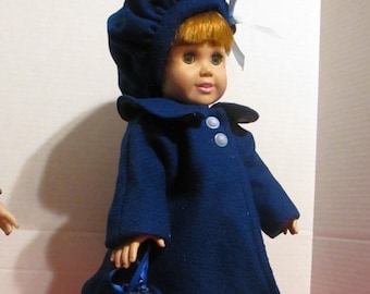 May include: A blue doll wearing a blue coat, a blue hat with a white bow, and a blue bag with a white bow. The doll has red hair and blue eyes.