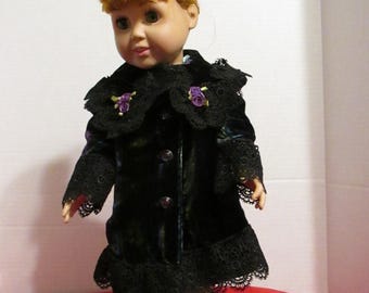 May include: A black velvet doll coat with lace trim and purple flower accents. The coat has a button closure and is worn by a doll with red hair.