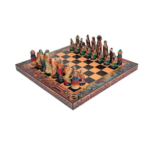 Puede incluir: Un tablero de ajedrez de madera con un diseño colorido e intrincado alrededor del borde. El tablero está configurado con un juego completo de piezas de ajedrez, cada una pintada con colores vibrantes y que representa figuras con vestimenta tradicional.