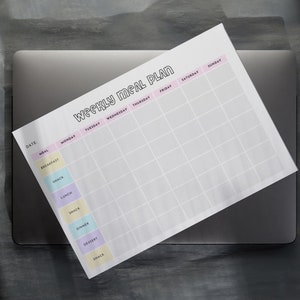 May include: A printable weekly meal planner with a white background and black text. The planner has columns for each day of the week and rows for different meals, including breakfast, snack, lunch, snack, dinner, dessert, and snack.