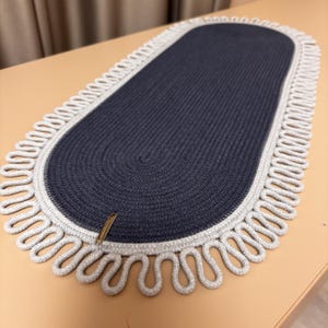 Puede incluir: Alfombra ovalada trenzada en azul marino y gris. El centro es azul oscuro, enmarcado por un borde gris y un borde decorativo con bucles. La alfombra está hecha de material tejido. Aproximadamente 120 cm x 60 cm, adecuada para varios estilos de decoración.