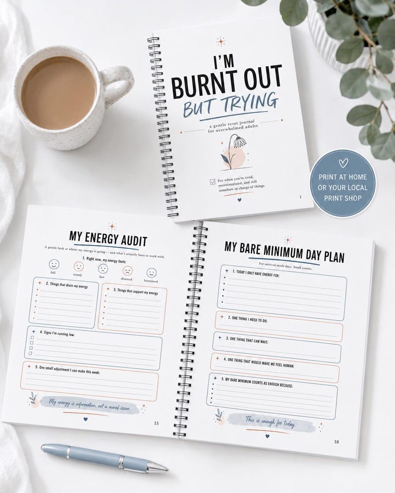 May include: A spiral-bound journal titled I'M BURNT OUT BUT TRYING with a gentle reset journal for overwhelmed adults subtitle. The open pages show My Energy Audit and My Bare Minimum Day Plan sections with prompts, checkboxes, and lines for writing.