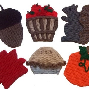 May include: Six crocheted felt ornaments in autumnal colors and themes: a brown acorn, a red maple leaf, a brown and gray squirrel, a tan pie, a pumpkin with a green stem, and a basket of red apples.