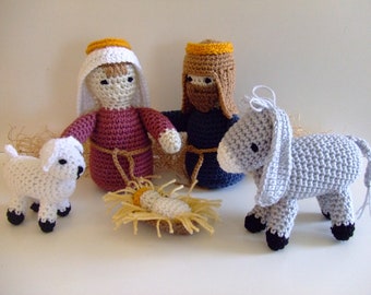 May include: A crocheted nativity scene with a white lamb, a gray donkey, a brown-haired woman in a burgundy robe, a brown-haired man in a blue robe, and a baby Jesus in a manger.