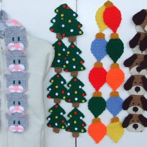 May include: A collection of handmade crochet items, including a gray cat scarf, green Christmas trees, colorful ornaments, and brown dog-shaped decorations. The items are displayed on a white background.
