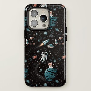 May include: A black phone case with a space-themed design. The case features a repeating pattern of astronauts, cats, planets, stars, and rockets on a black background.
