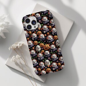May include: A black phone case featuring a repeating pattern of cartoon ghosts wearing headphones, pumpkins, and purple flowers. The case has a glossy finish and a camera cutout. The design is set against a black background, creating a festive Halloween theme.