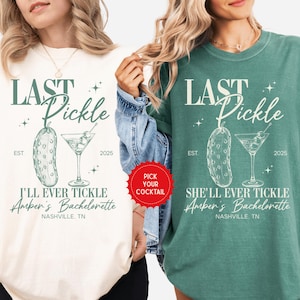 May include: Two t-shirts, one cream and one green, with the text "LAST Pickle" and a pickle and martini glass graphic. The cream shirt says "I'LL EVER TICKLE Amber's Bachelorette Nashville, TN". The green shirt says "SHE'LL EVER TICKLE Amber's Bachelorette Nashville, TN".