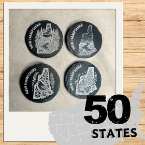 Puede incluir: Cuatro posavasos de pizarra negra con un contorno blanco del estado de New Hampshire y varios diseños. Los posavasos están dispuestos en forma de cuadrado. El texto "NEW HAMPSHIRE" está escrito en un arco blanco alrededor del contorno del estado. El texto "50 STATES" está escrito en blanco sobre fondo negro en la esquina inferior derecha de la imagen.