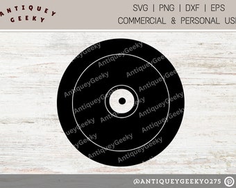 May include: Black and white target with concentric circles. The target is on a white wood background. The text "AntiqueyGeeky" is repeated around the target.
