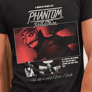 May include: Black t-shirt featuring the movie title "Phantom of the Paradise" with a red and black graphic. The shirt includes text from the film, "My music is for Phoenix. Only she can sing it. Anyone else who tries, dies!"
