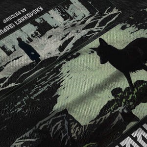 May include: Black fabric with a film-inspired design. The image features a silhouette of a figure and a wolf-like animal against a backdrop of a forest scene. Text includes "DIRECTED BY ANDREI TARKOVSKY".