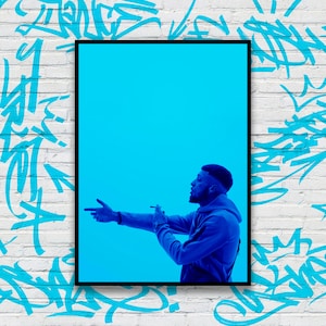 Peut inclure: Un homme portant un sweat à capuche bleu se tient devant un fond bleu vif. Il regarde vers la droite et tient une cigarette dans sa main droite.