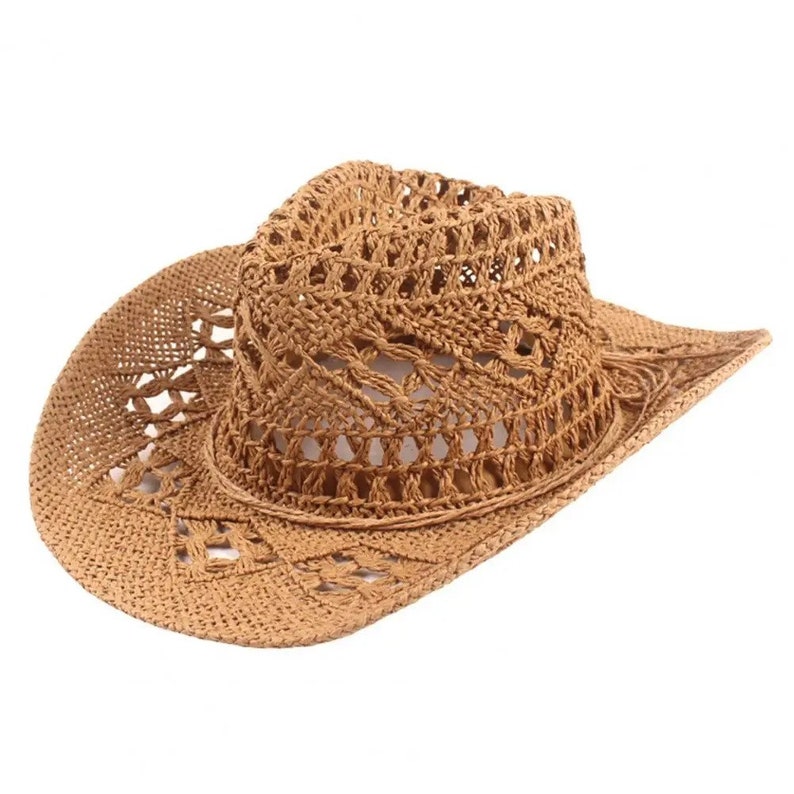 Puede incluir: Sombrero de vaquero marr&oacute;n claro hecho de paja tejida. El sombrero presenta un ala ancha y un dise&ntilde;o de tejido abierto detallado en la corona y el ala. El sombrero est&aacute; dise&ntilde;ado para proteger del sol.