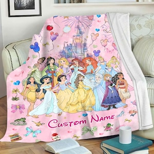 May include: Pink fleece blanket featuring a pink castle and a group of Disney princesses. The blanket is personalised with the name "Custom Name".