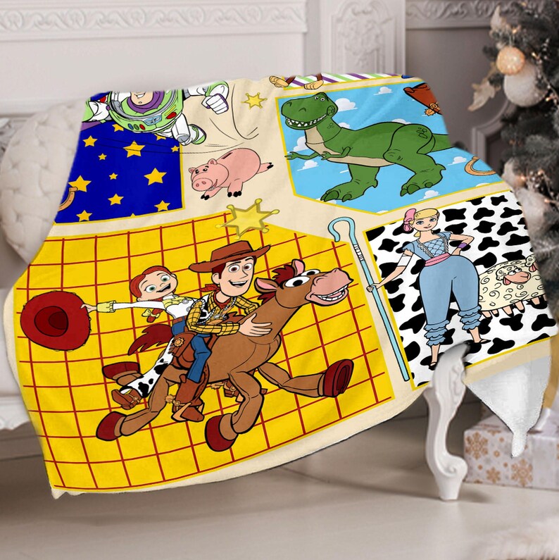 Puede incluir: Una manta amarilla y marr&oacute;n con un dise&ntilde;o de patchwork que presenta personajes de la franquicia Toy Story. Los personajes incluyen a Woody, Buzz Lightyear, Jessie, Rex y un dinosaurio. La manta est&aacute; hecha de tela suave y c&oacute;moda, perfecta para acurrucarse en el sof&aacute;.
