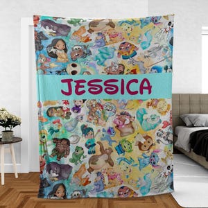 K&ouml;nnte beinhalten: Eine farbenfrohe Decke mit verschiedenen Zeichentrickfiguren im Aquarellstil. Die Decke hat ein hellblaues Band mit dem Namen "JESSICA" in rosa Buchstaben. Die Decke ist eine Mischung aus Gelb, Blau und Wei&szlig;.