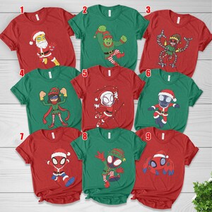 May include: A collection of nine short-sleeved t-shirts in red and green, each featuring a unique cartoon character dressed in holiday attire, including Santa suits and elf costumes, with numbered labels from one to nine displayed above each shirt.