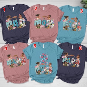 May include: Six short-sleeved crew neck t-shirts in navy, dusty rose, and teal. Each shirt features a graphic print of characters from the movie Moana integrated into large block letters spelling DAD, MOM, GIRL, NANA, 2 NAME, and PAPA.