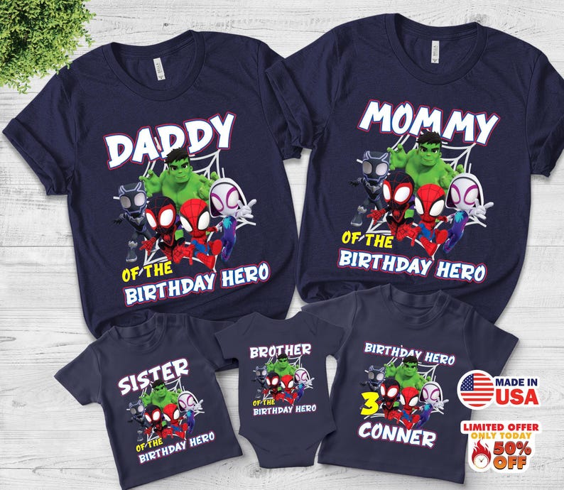 Puede incluir: Un conjunto de camisetas azul marino y un body de beb&eacute; con un gr&aacute;fico de superh&eacute;roes de Marvel que incluye a Hulk, Black Panther y Spider-Man. Las prendas muestran textos como DADDY, MOMMY, SISTER, BROTHER y BIRTHDAY HERO.