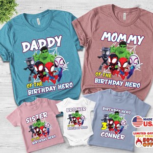 Puede incluir: Una colecci&oacute;n de cinco camisetas y un body en azul, rosa y blanco, con gr&aacute;ficos de superh&eacute;roes de dibujos animados como Hulk, Black Panther y Spider-Man. El texto incluye DADDY, MOMMY, SISTER, BROTHER y BIRTHDAY HERO CONNER.