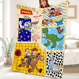 Puede incluir: Una manta colorida con personajes de la franquicia Toy Story. La manta es amarilla con un patr&oacute;n de cuadr&iacute;cula y presenta im&aacute;genes de Woody, Buzz Lightyear, Jessie, Rex y otros personajes. La manta tambi&eacute;n incluye el texto "Olivia's Story".