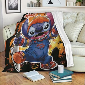 May include: A Halloween-themed throw blanket featuring a cartoon character dressed as Chucky, holding a knife. The character is in a blue jumpsuit with "Good Guys" printed on it. The background includes pumpkins and a silhouette of a graveyard.