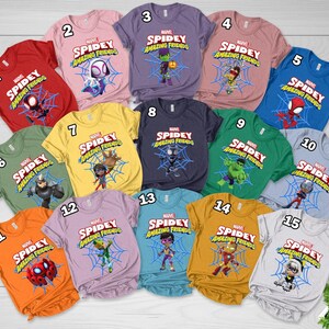 May include: A collection of fifteen short-sleeved t-shirts in various colors, each featuring a Marvel Spidey and His Amazing Friends graphic with a character centered on a blue spiderweb and the show title text printed above in red and white.