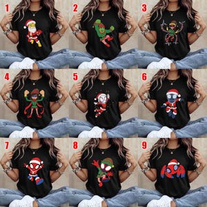 May include: A collection of nine black short-sleeved t-shirts, each featuring a different graphic print of a character dressed in holiday-themed attire, including Santa suits and elf costumes, displayed in a grid layout on a neutral background.