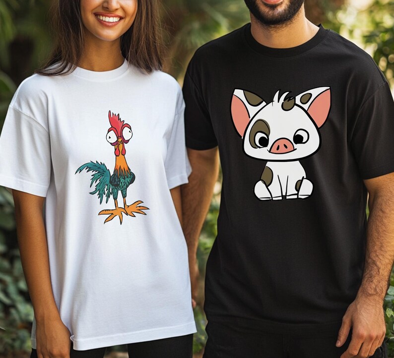 Puede incluir: Una camiseta blanca con un gallo de dibujos animados colorido de ojos grandes y una camiseta negra con un cerdito de dibujos animados de ojos grandes, orejas rosas y manchas marrones. Ambas camisetas tienen mangas cortas y cuello redondo.