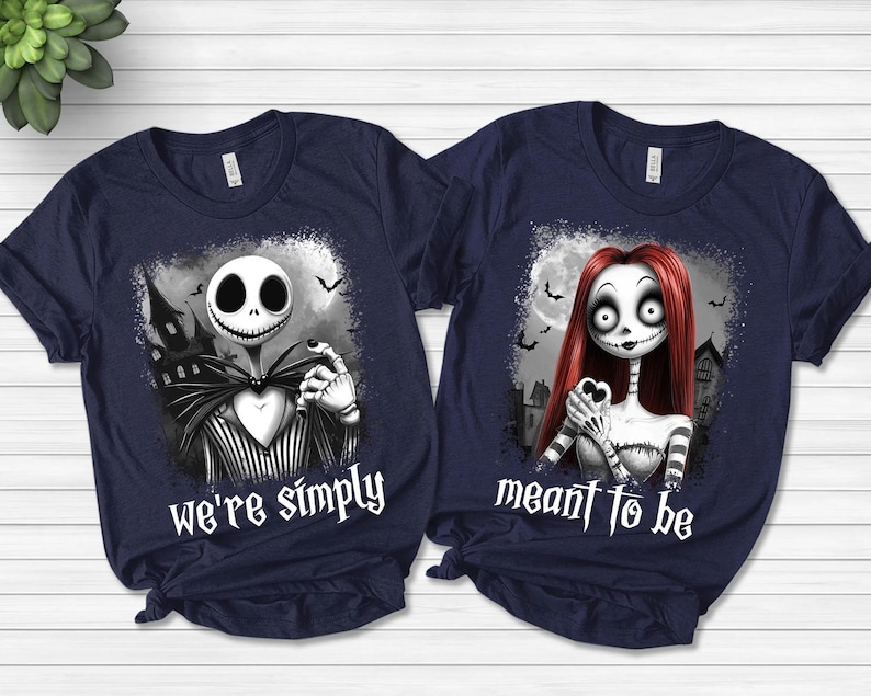 May include: Two navy blue short-sleeve t-shirts featuring graphic prints of characters from The Nightmare Before Christmas. The left shirt displays Jack Skellington with the text we're simply, and the right shirt displays Sally with meant to be.