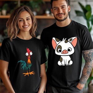 Puede incluir: Dos camisetas negras de manga corta y cuello redondo. Una camiseta presenta un gr&aacute;fico colorido de un gallo de ojos grandes con plumas rojas, naranjas y verde azulado. La otra camiseta muestra un gr&aacute;fico de un cerdito blanco con manchas marrones.