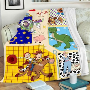 Puede incluir: Una manta de forro polar colorida con personajes de la franquicia Toy Story. La manta est&aacute; dividida en cuadrados con diferentes escenas de la pel&iacute;cula, incluyendo a Woody montando a caballo, Buzz Lightyear volando y Rex el dinosaurio. La manta es perfecta para acurrucarse en el sof&aacute; o llevarla a una noche de cine.