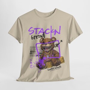 Unisex Stackin Bread Teddy Graphic T-Shirt in Sand Color with an eye-catching teddy bear design. Perfect for casual streetwear outfits or gifting, this shirt combines bold graphics with everyday wearability. Designed for fans of urban fashion.