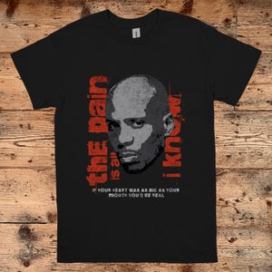 May include: Black t-shirt with a red and white graphic of a man's face and the text "the pain is all i know" and "IF YOUR HEART WAS AS BIG AS YOUR MOUTH YOU'D BE REAL".