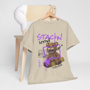Make a statement with the Stackin Bread Teddy Graphic T-Shirt in Sand, designed for streetwear fans. Featuring a bold teddy bear design, this shirt offers comfort and style in equal measure. Perfect for men and women who love trendy fashion